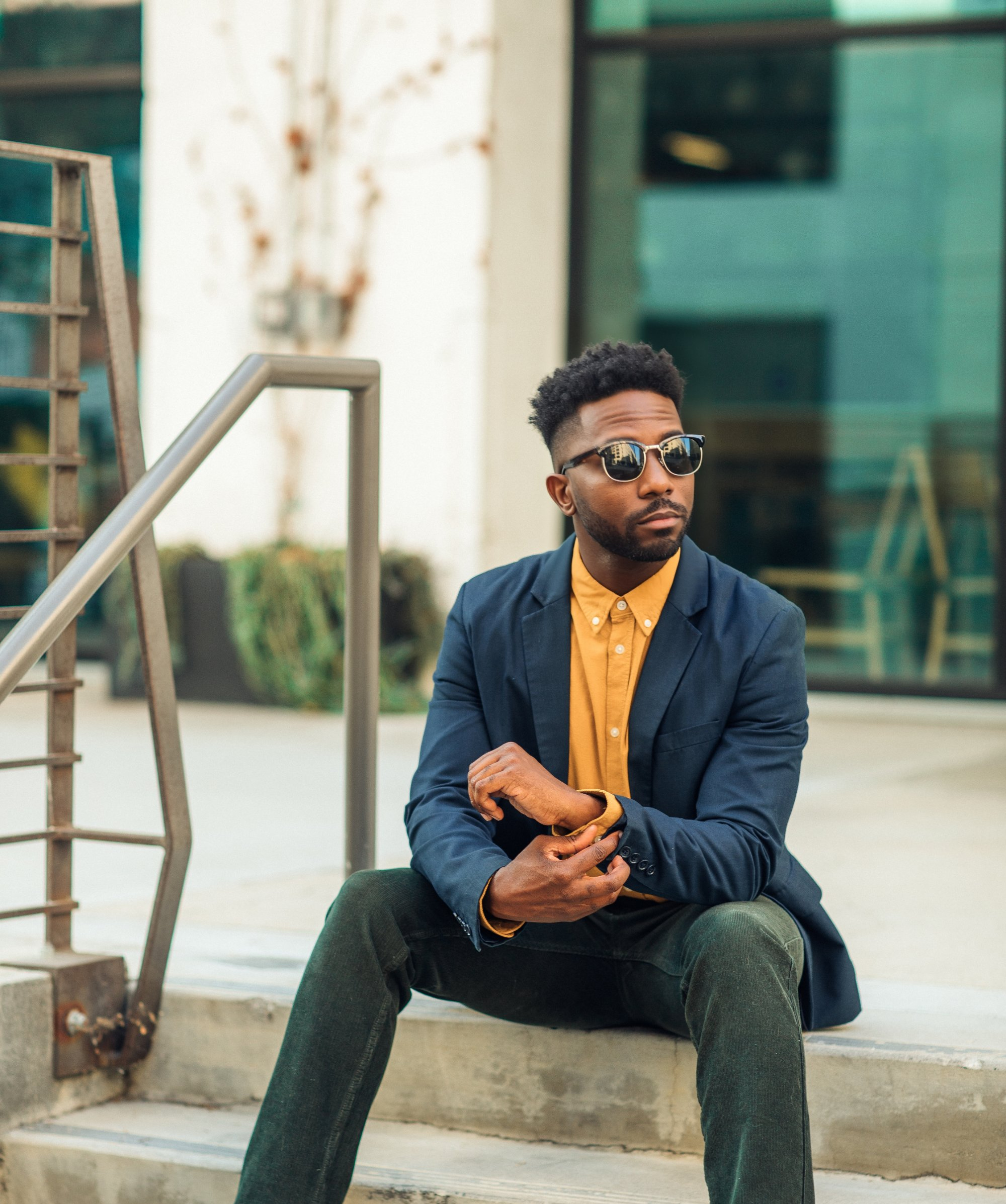 Actor Dennis Pearson sitting in a suit and wearing sunglasses